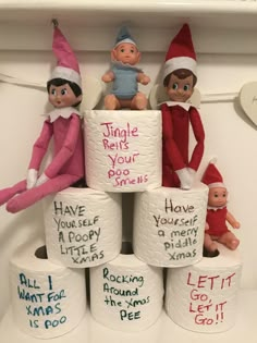 the elfs are sitting on top of toilet paper rolls that have writing on them