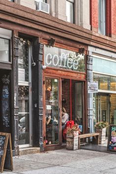 a coffee shop on the side of a street with people sitting at tables outside it