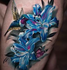 a tattoo with blue flowers and a humming bird on it