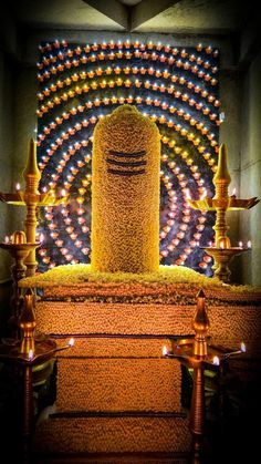 an artistic display with candles and lights in the shape of a tower on top of some steps