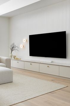 a large flat screen tv mounted to the side of a wall in a living room