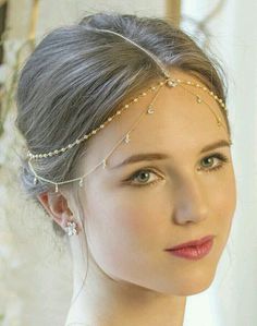 a woman wearing a head piece with pearls on it