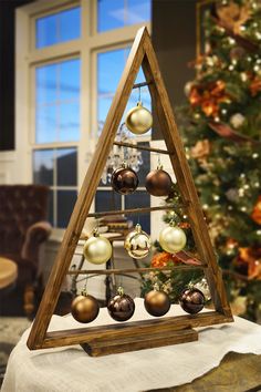 a wooden christmas tree with ornaments hanging from it