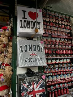 i love london sign hanging on the wall next to other signs and teddy bears for sale