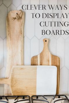 two wooden cutting boards sitting next to each other on top of a stove with the words clever ways to display cutting boards