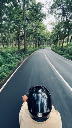 a person riding on the back of a motorcycle down a curvy road