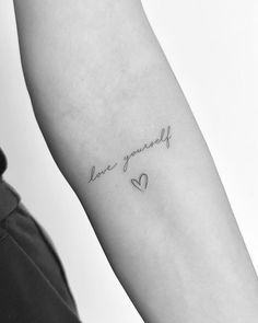 a woman's arm with the words love yourself on it and a small heart