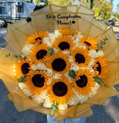 a bouquet of sunflowers is held in front of a person holding an umbrella