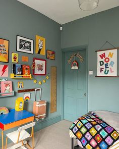 a child's bedroom with blue walls and pictures on the wall