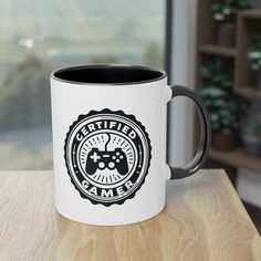 a white and black coffee mug sitting on top of a wooden table