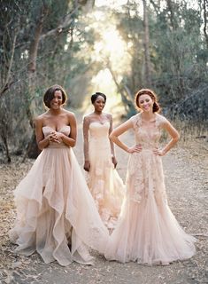 three beautiful women in dresses standing together