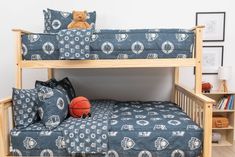 a bunk bed with a basketball on the bottom and blue patterned bedspread over it