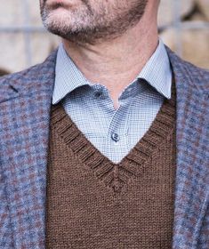 a man wearing a brown vest and blue shirt