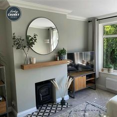 a living room filled with furniture and a fire place in front of a tv mounted on a wall