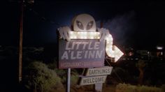 a sign that says little aleinn restaurant and bar - note is lit up at night