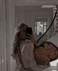 a woman taking a selfie while holding a bouquet of roses