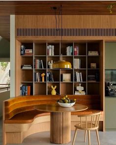 a wooden table sitting in front of a bookshelf