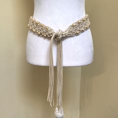 a white mannequin with a gold chain belt on it's waist,