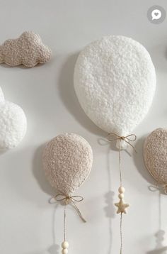 three hot air balloons hanging from strings on the wall with pearls and beads attached to them