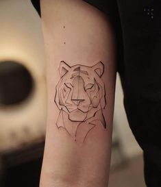 a small tiger tattoo on the arm