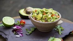 an avocado salad in a bowl on a cutting board