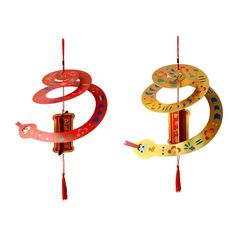 two colorful wind chimes hanging from strings on a white background with red tassels