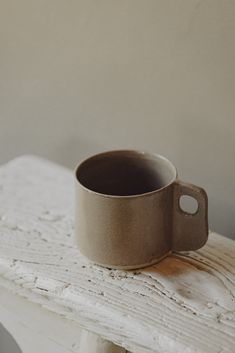 a brown cup sitting on top of a white table