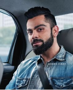 a man with a beard sitting in a car