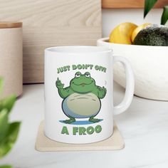 a coffee mug that says, just don't give a frog on the front