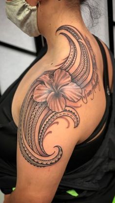 a woman with a flower tattoo on her shoulder