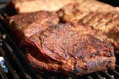 two steaks are cooking on the grill