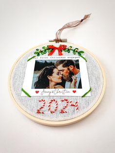 a christmas ornament with a photo and candy canes hanging from it's side