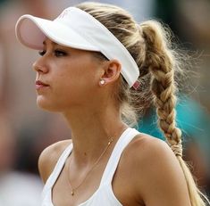 a female tennis player with a ponytail in her hair and a white visor on