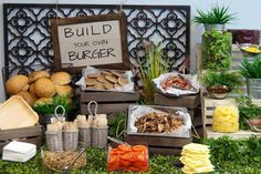 an assortment of food is displayed on a table with a sign that says build your own burgerer