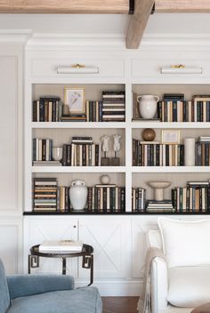 a living room filled with furniture and bookshelves covered in white bookcases