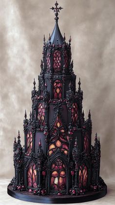 an elaborately designed cake is displayed on a table with red and black frosting