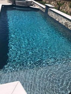 an outdoor swimming pool with steps leading up to it and water running down the side