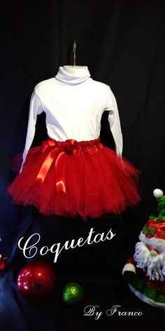 a white shirt and red tutu skirt with santa clause on it next to christmas decorations