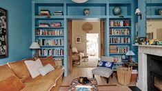 a living room filled with furniture and bookshelves next to a fire place in front of a fireplace