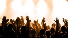 a group of people with their hands up in the air at a concert or show