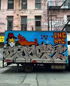 a truck with graffiti on it parked in front of a building