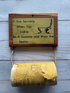 an old fashioned toilet paper dispenser on a white wooden background with text