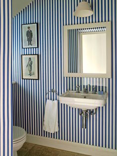 a bathroom with blue and white striped walls