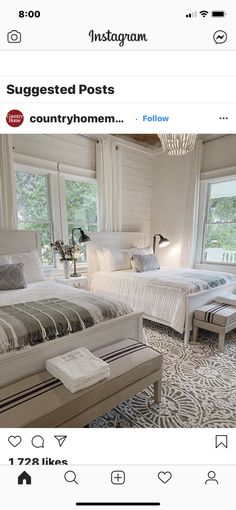 two beds in a room with white walls and windows