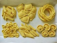 several different types of pasta noodles in a white box on a table with other items