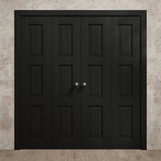 an empty room with two black doors on the wall and wood flooring in front of it