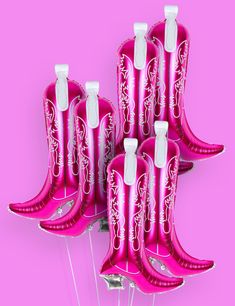 six pink cowboy boots with white laces on them sitting in front of a pink background