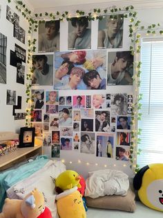 a bedroom with posters and stuffed animals on the wall