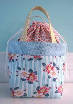 a blue and white flowered bag sitting on top of a table next to a wall