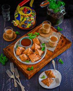 some food is sitting on a table with silverware and cups in front of it